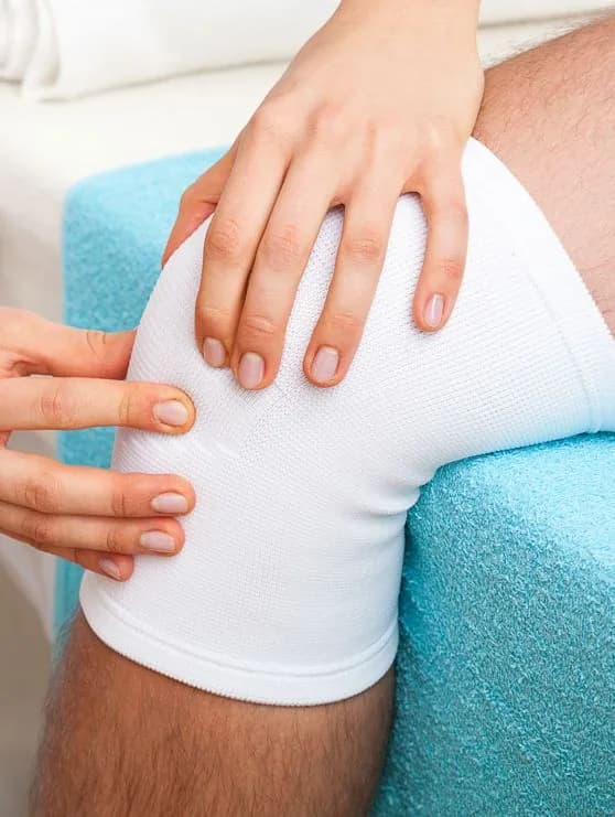 Close-up of a physiotherapist's hands mobilizing a patient's shoulder joint